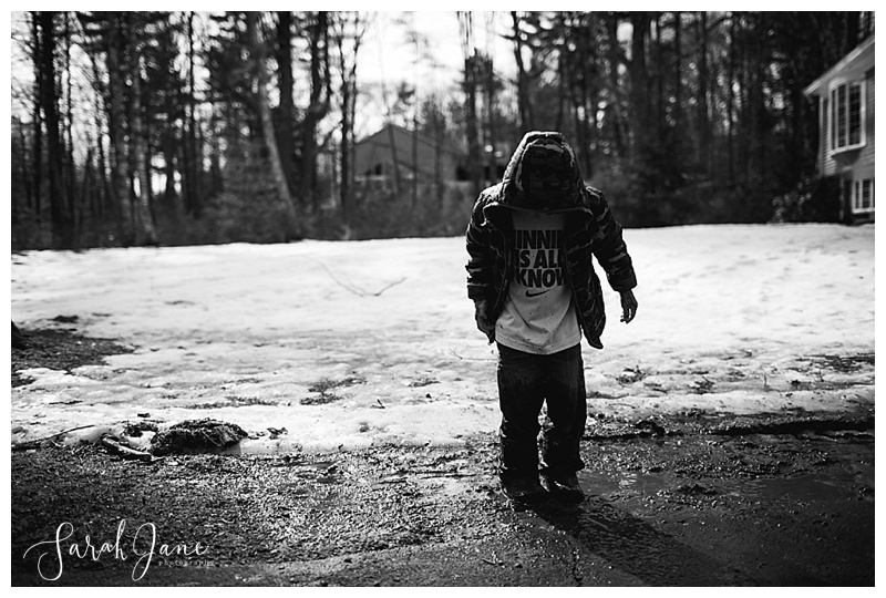 kid playing in the mud in spring in Maine