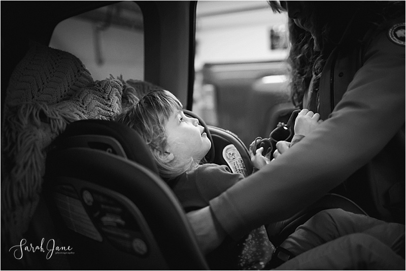 Child being buckled into car seat Sarah Jane Photography