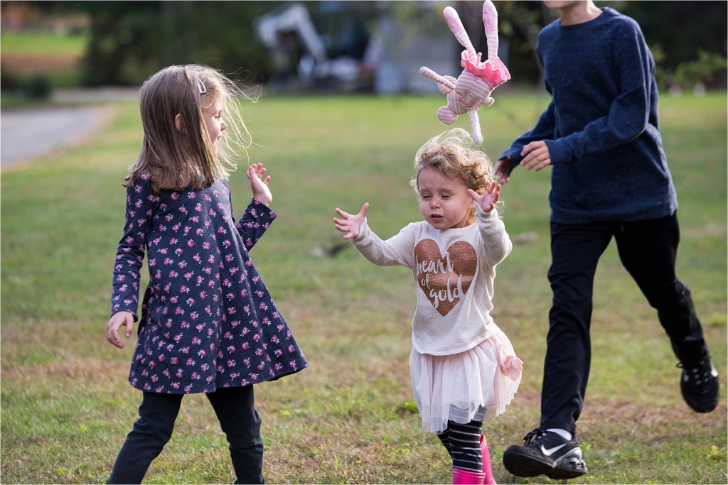 Bigger siblings teasing little sister with her toy