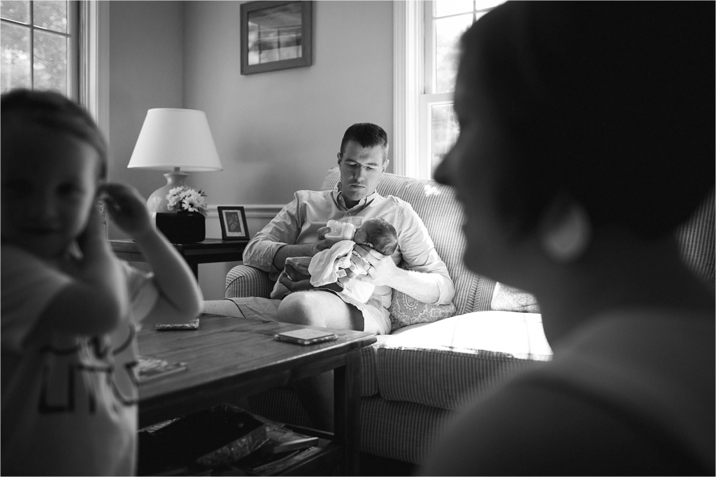 dad feeds baby black and white photograph lifestyle photo session maine family photographer