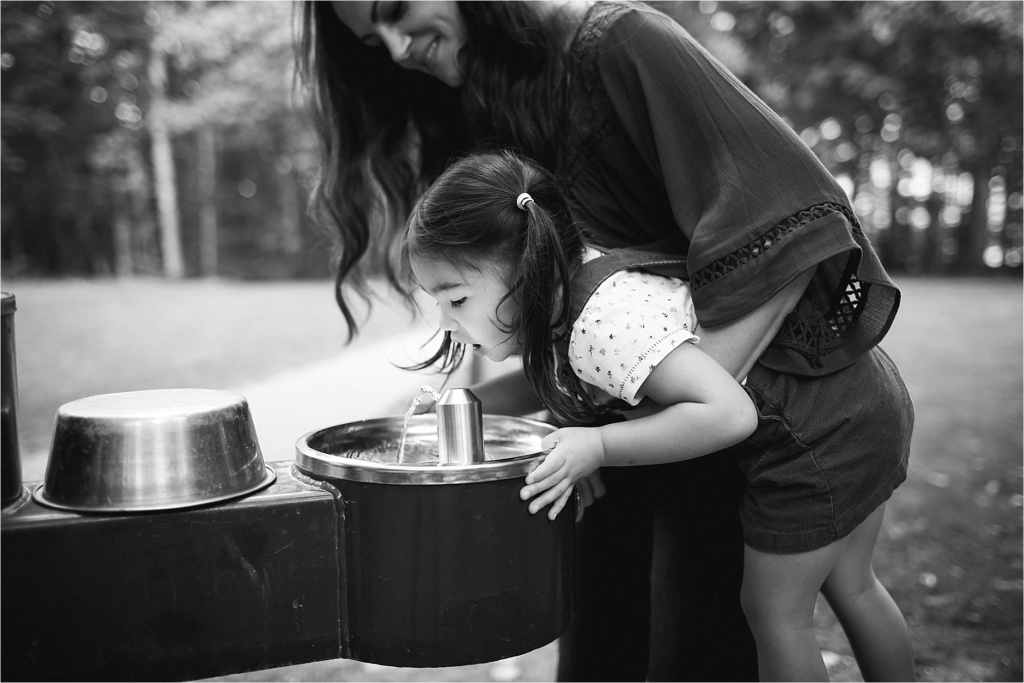 small child drinking from water fountain, black and white photo, family lifestyle photo session
