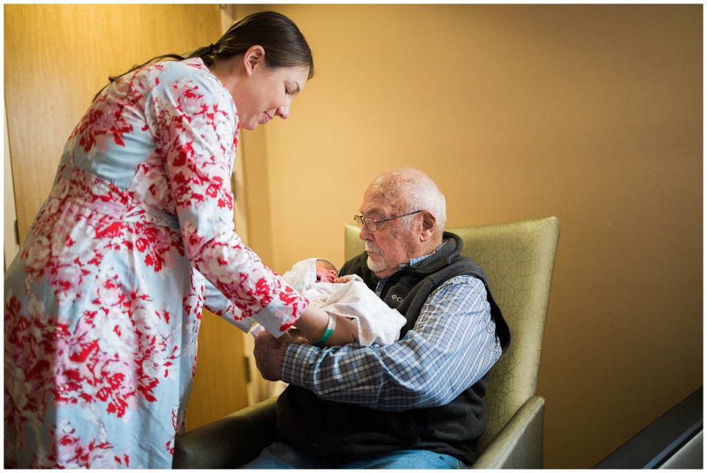 great grandfather holds baby for the first time
